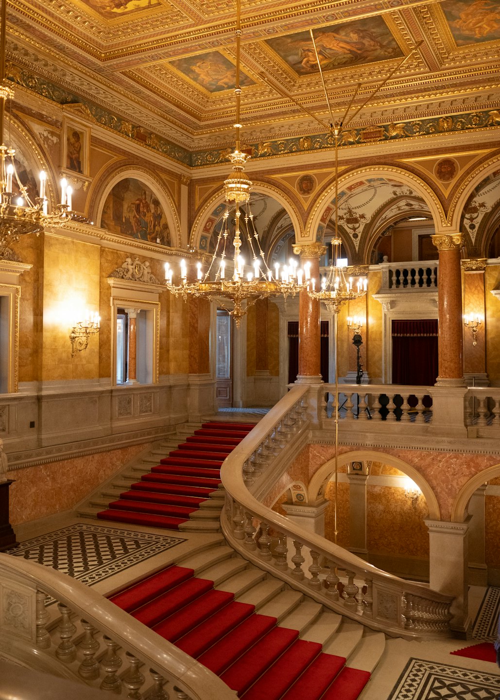 Grande scalinata con tappeto rosso in un palazzo storico.