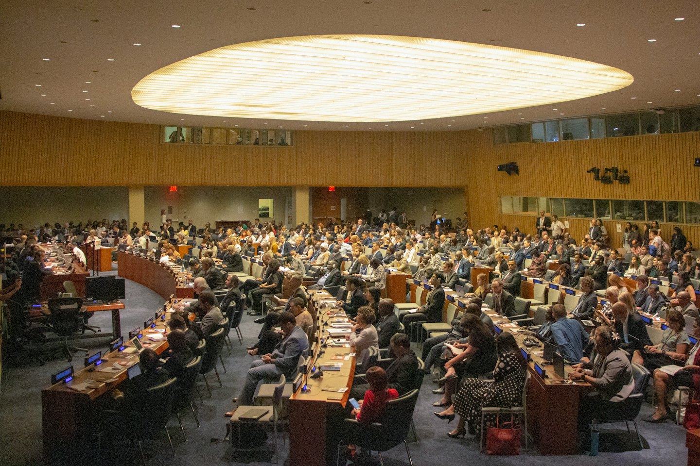 Delegati seduti alle scrivanie in un grande centro congressi.