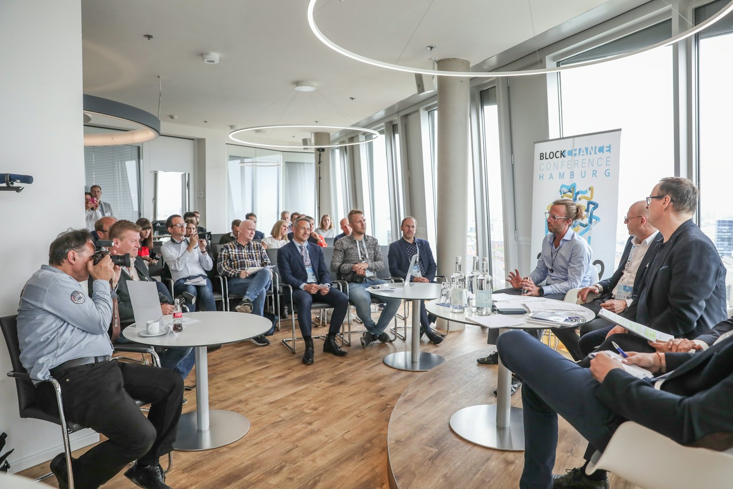 Professionisti a una conferenza che scattano foto ai relatori.