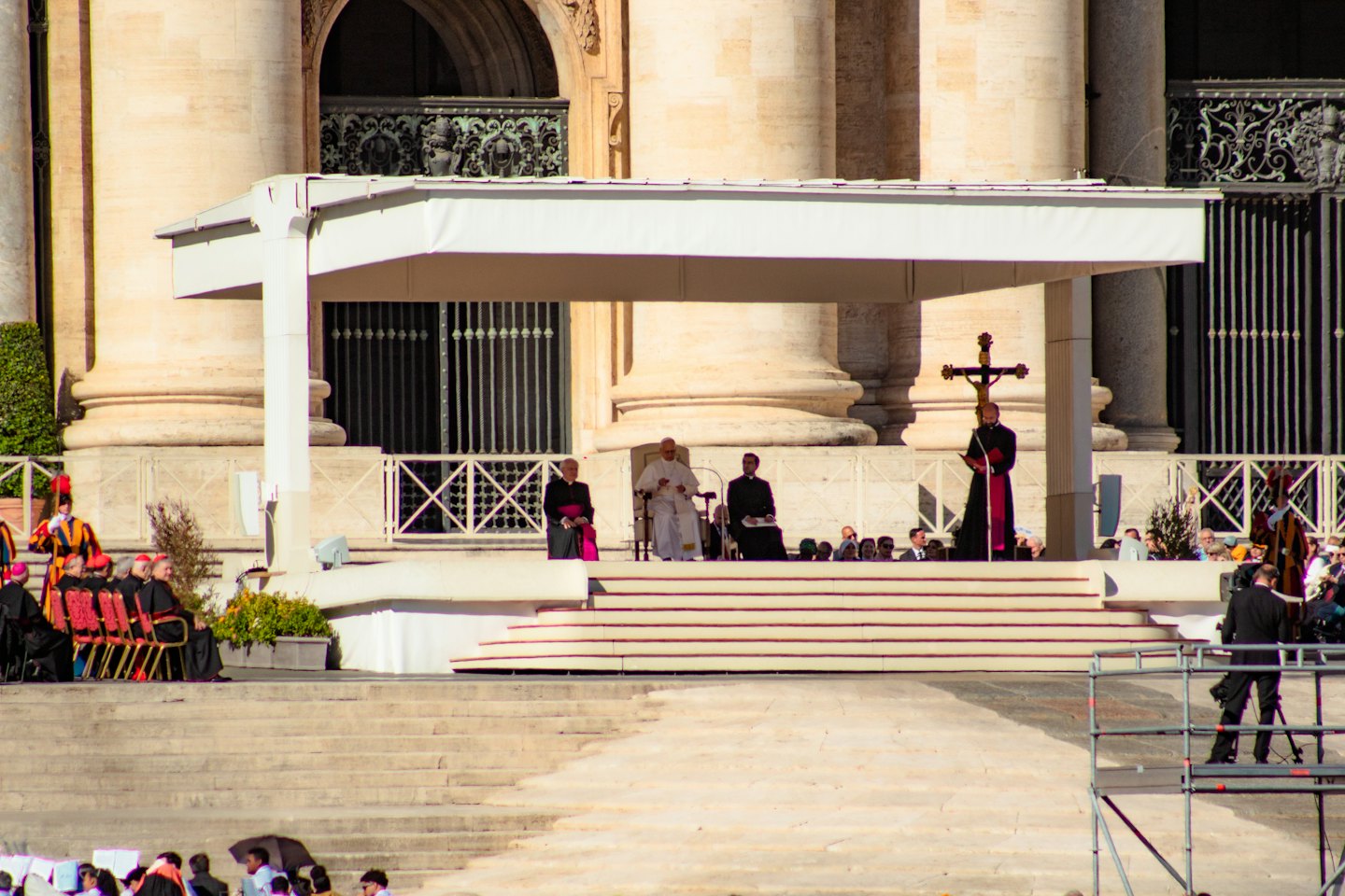 Membri del clero siedono su un palco davanti a un'architettura classica.